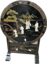 An oriental flip top lacquered table set with geisha mother of pearl inlaid scene