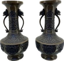 A Pair of antique Chinese Bronze urn vases; detailed with dragon head handles, Ornate trims and