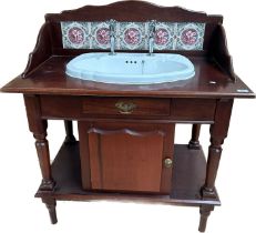 Antique mahogany wash stand, the shaped back with ceramic tiles above a ceramic sink and a single