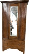 19th century wardrobe, the moulded cornice above a mirrored door, flanked by beaded panels, the