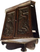 Late Victorian wall cabinet, the moulded cornice over two carved cupboard doors opening to a shelved