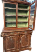 19th century walnut display unit, the glazed doors opening to shelves surmounted by scroll detail,