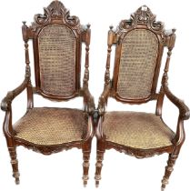 A pair of Victorian armchairs, the cane back surmounted by moulded carved foliate design above a