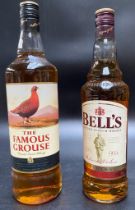 A bottle of famous grouse scotch whisky & A bottle bells blended scotch whisky.