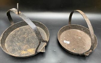 A collection of two cast iron skillet pots [33cm diameter]