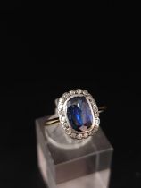 A sapphire and diamond cluster ring, a cushion shaped mixed cut sapphire approx 6mm x 9mm. Weight