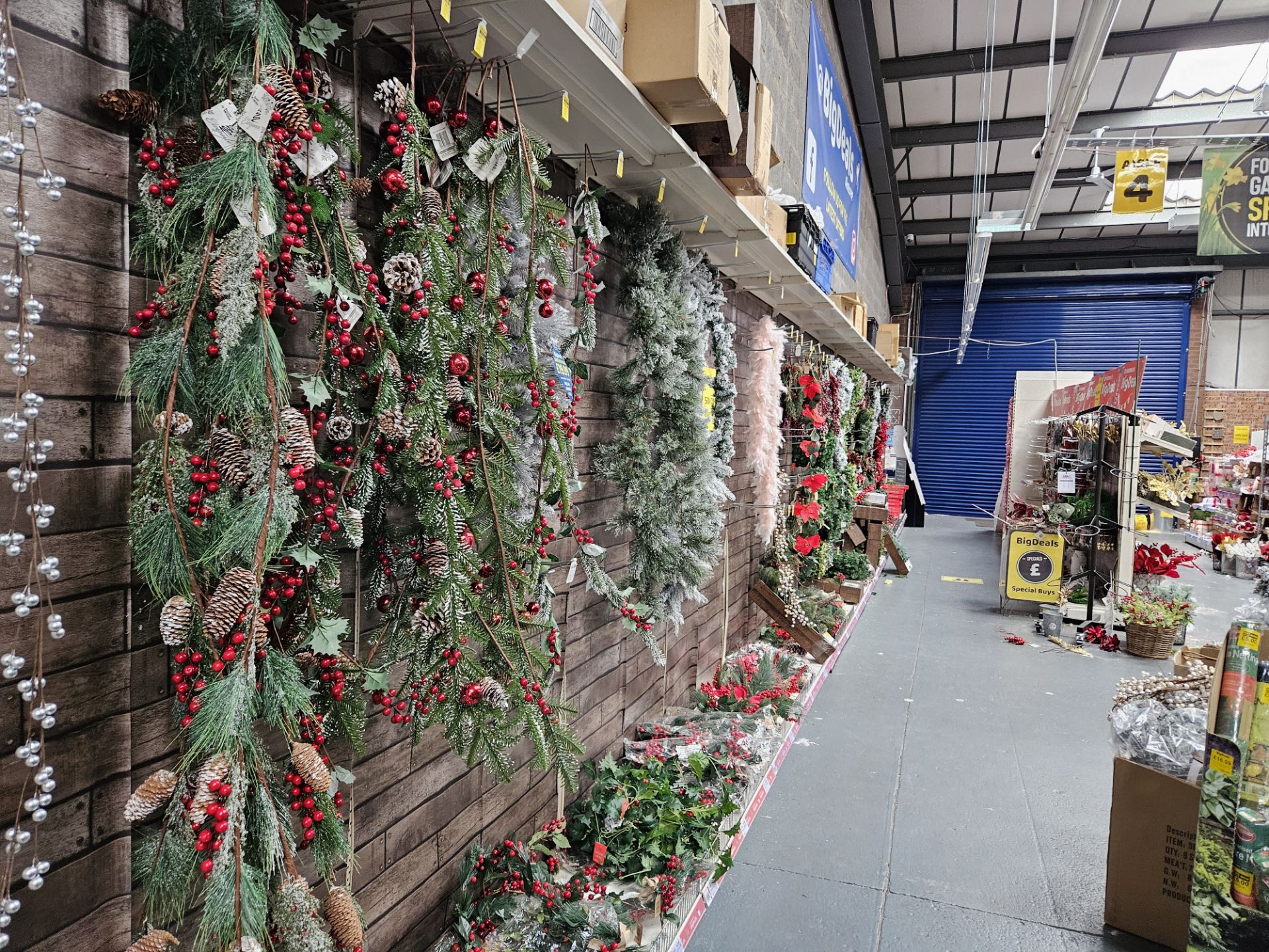 Large quantity of fake christmas foliage to include wreaths, garlands branches & flowers.