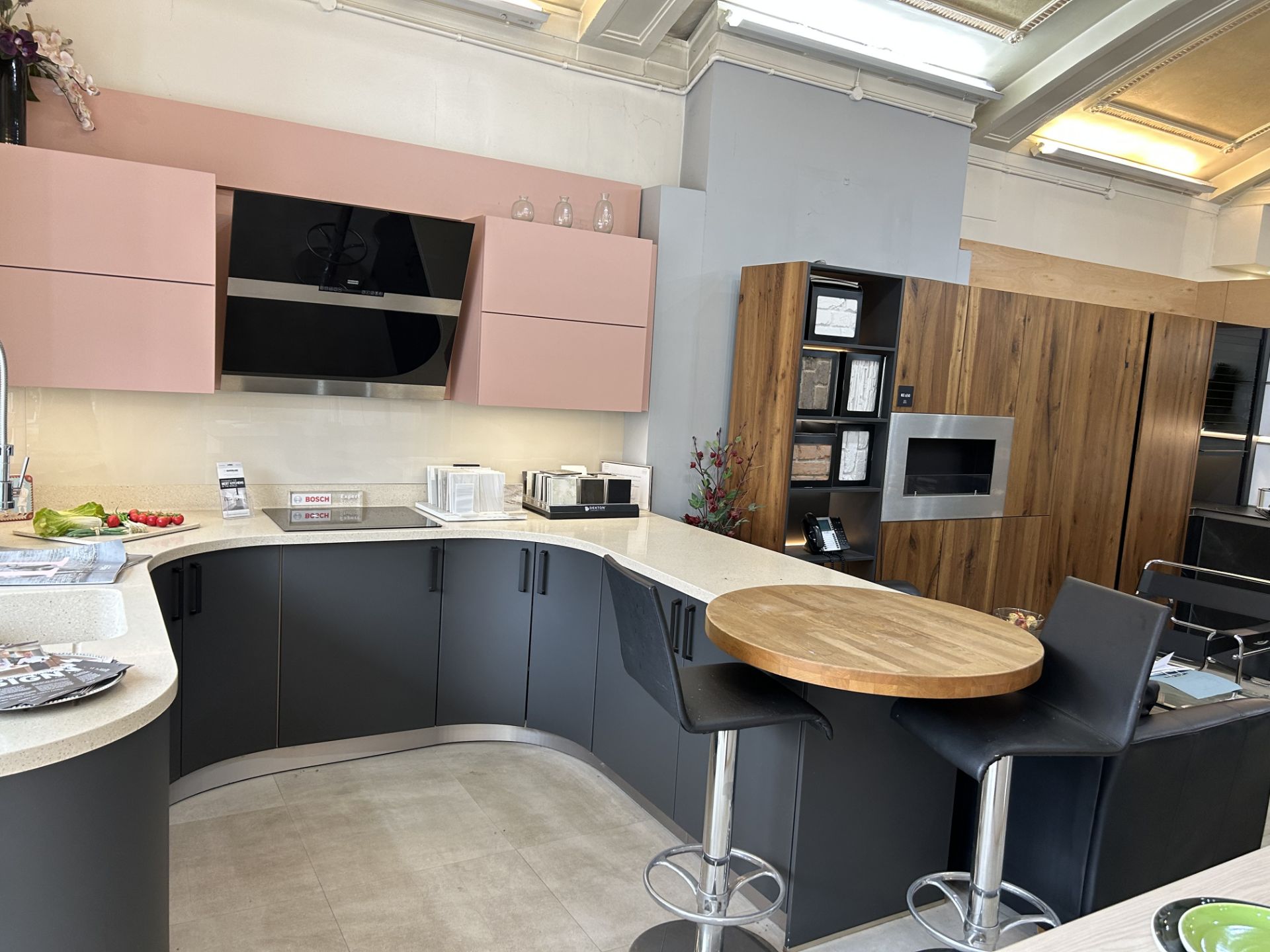 Display Kitchen in dark navy with cream speckled work surface and pink wall mounted cupboard units - Image 3 of 8