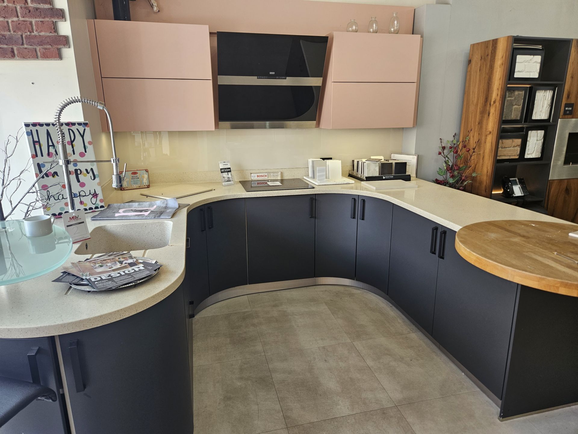 Display Kitchen in dark navy with cream speckled work surface and pink wall mounted cupboard units - Image 2 of 8