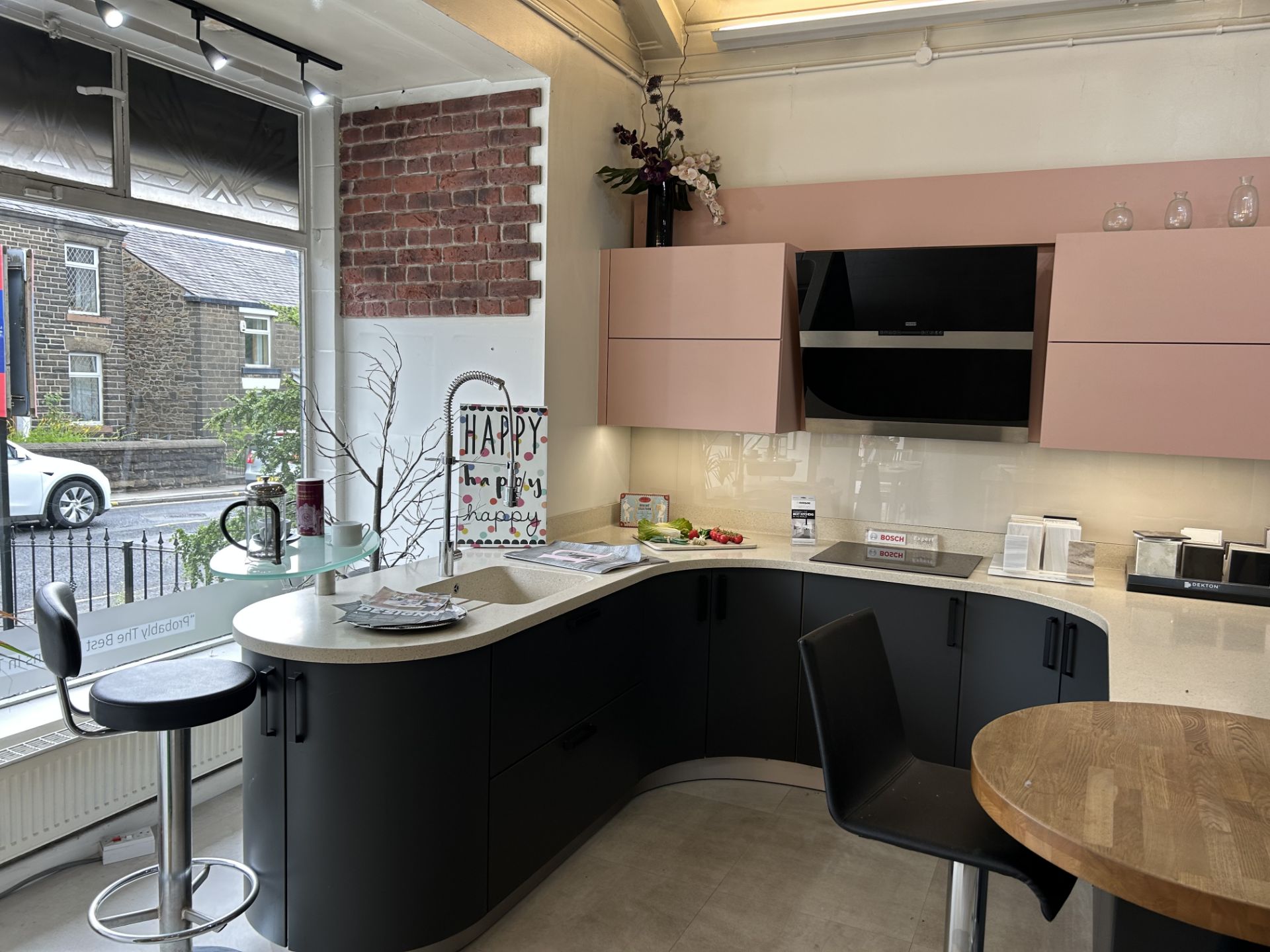 Display Kitchen in dark navy with cream speckled work surface and pink wall mounted cupboard units - Image 4 of 8