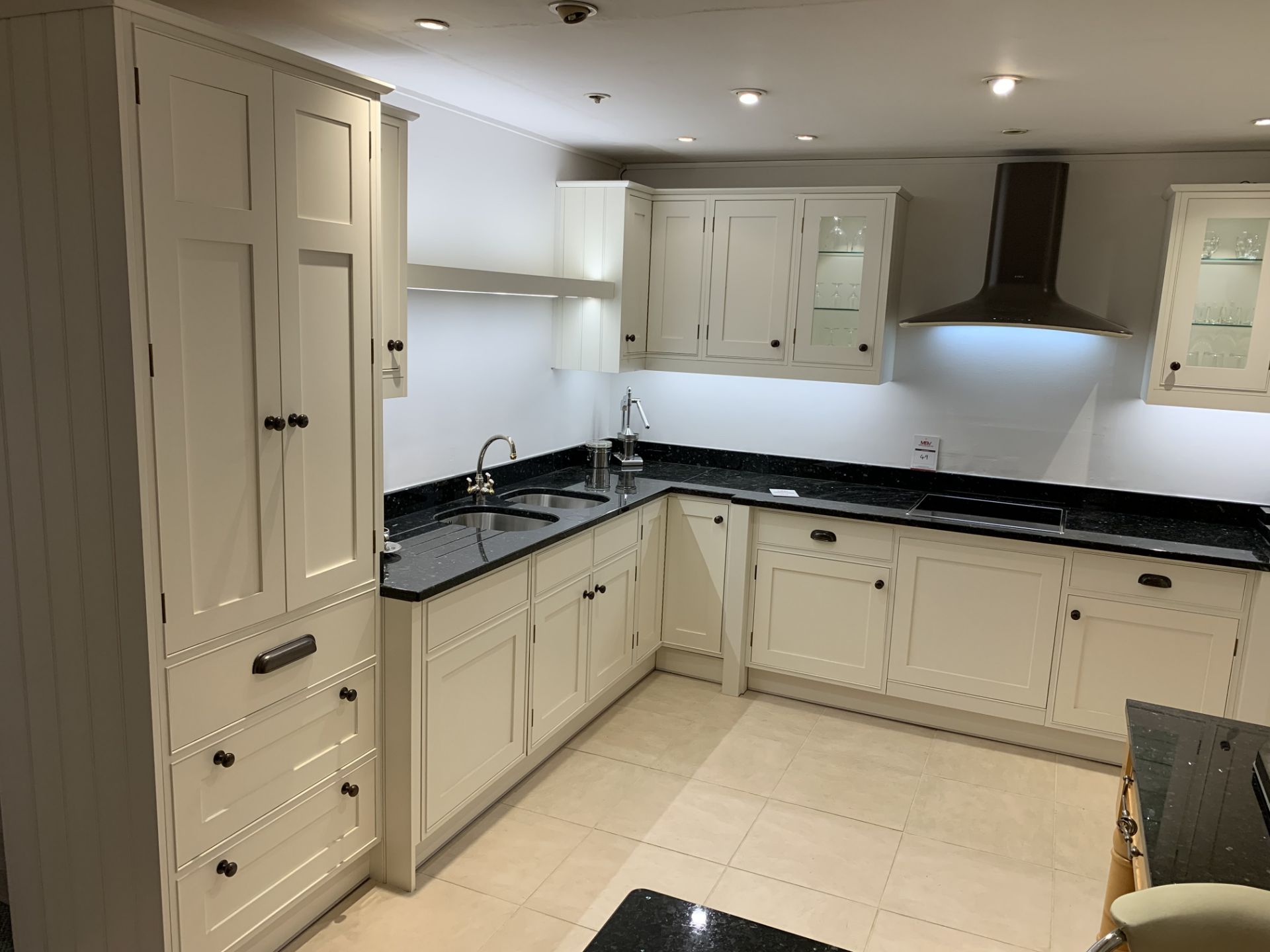 Display L-shaped kitchen in flat white with black granite work surface