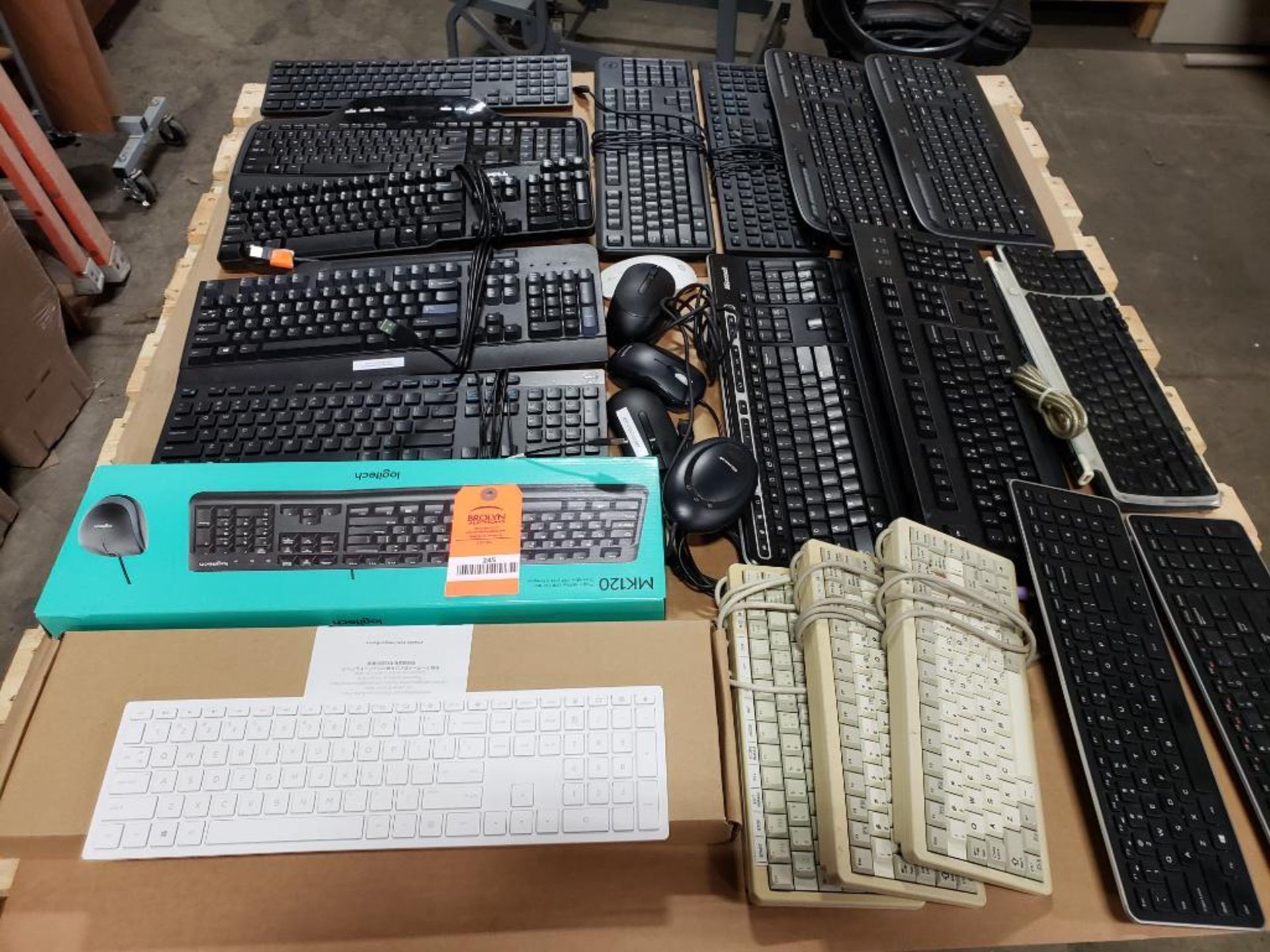 Pallet of assorted computer keyboards, mouse. Dell, Apple, Logitech, HP.