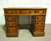 A compact Victorian mahogany kneehole desk, late 19th century, with a rounded rectangular