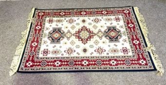 Four assorted rugs, including a small Kazak rug with three medallions on a cream ground, a runner
