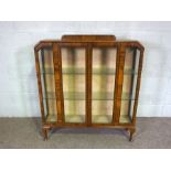 An Art Deco walnut veneered china cabinet, with glass shelves, 132cm high, 125cm wide