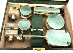 A vintage green leather travelling case, and matching vanity case, with silver and enamel by