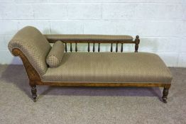 An Edwardian chaise longue, with walnut turned feet and bobbin turned back supports, currently