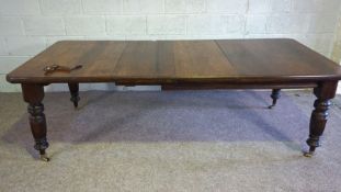 An Edwardian oak extending dining table, early 20th century, with a solid top, on four ring turned