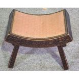 An Anglo Indian carved footstool, with decorative frieze; together with a long stool and another