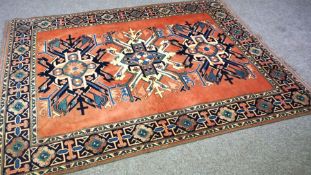 A modern Kazak tribal rug, with three stylised medallions on a pink ground, 216cm x 162cm