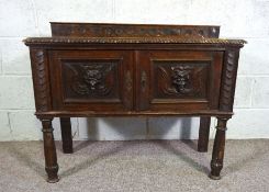 A compact Jacobean style dresser base, with moulded carved front and two doors, 76cm high, 95cm