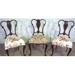 A set of three Edwardian mahogany salon chairs, with scrolled backs and vase carved splats