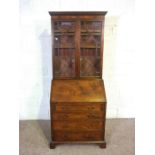 A George III style mahogany bureau bookcase, 20th century, of compact size, with a moulded dentil