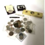 An assortment of commemorative coins, a commemorative tin,  two penknives and a pair of cufflinks (