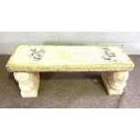 An Italian style composition stone garden bench, circa 2000, with weathered top, set on sphinx