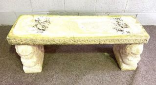 An Italian style composition stone garden bench, circa 2000, with weathered top, set on sphinx