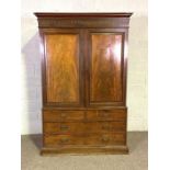 A George IV mahogany linen press, 19th century, with two panelled press doors, opening to a