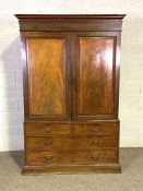 A George IV mahogany linen press, 19th century, with two panelled press doors, opening to a