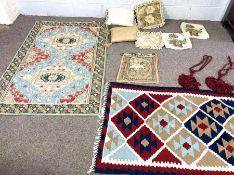 A bag of decorative cushions and covers and an Indian decorative textile panel, of an equestrian