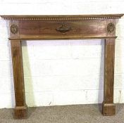 A vintage Adam style stained pine fire surround, 20th century, with dentil cornice, urn centred