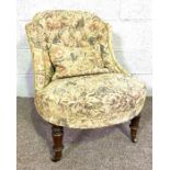 An Victorian style small upholstered nursing chair, with floral buttoned back and brass castors