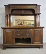 A large late Victorian oak sideboard, circa 1900, with a high mirrored gallery back, flanked by