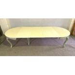 A vintage extending oval dining table, with cream painted top, cabriole legs and sage green