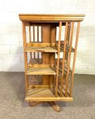 A vintage rotating bookstand, 20th century, of typical square form, with slatted supports and set on