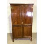 A Regency style double wardrobe, with two panelled doors, on tall tapered feet, 198cm high, 113cm