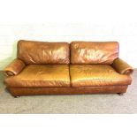 A vintage leather sofa, with long deep seat band brass hob-nailed scrolled ends, 230cm long