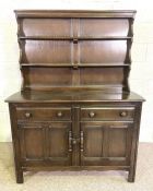 A modern Ercol style beech wood dresser, with a rack over a base with two drawers and two cabinet