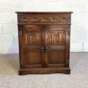 An oak Jacobean style music cabinet, with rising top and two cabinet doors. (Could be updated for