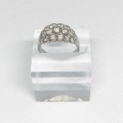 A diamond cluster engagement ring, white metal band (probably platinum), with three rows of small