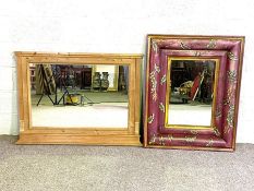 Two large wall mirrors; one with a cushioned frame and painted with leaves; the other a stripped