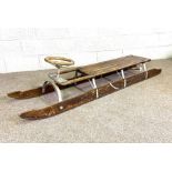 A vintage bobsled (or steerable toboggan), circa 1930, the long two person ash and iron sledge