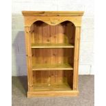 A small pine open bookcase, with serpentine frieze and two fixed shelves, 122cm high, 77cm wide,