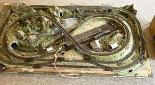 A large vintage trainset diorama, with various tunnels, buildings and landscaping, set on a board