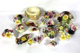A large assortment of ceramic posies of flowers, in various vases and sizes, naturalistically
