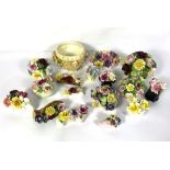 A large assortment of ceramic posies of flowers, in various vases and sizes, naturalistically