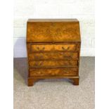 A Georgian style walnut veneered bureau, with sloping fall front, and four drawers 95cm high, 76cm